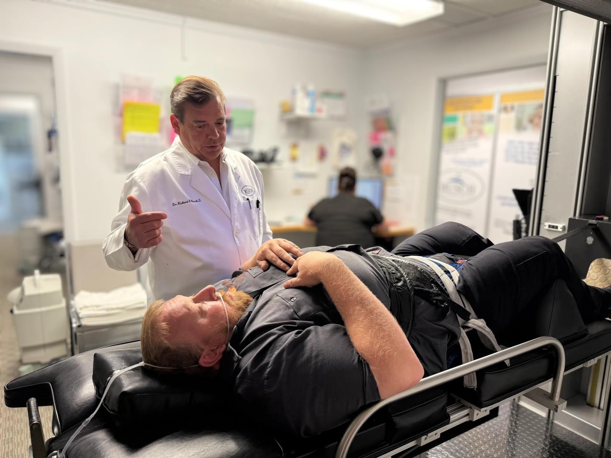 Dr. Busch consulting with a patient on the DRS Protocol® decompression table