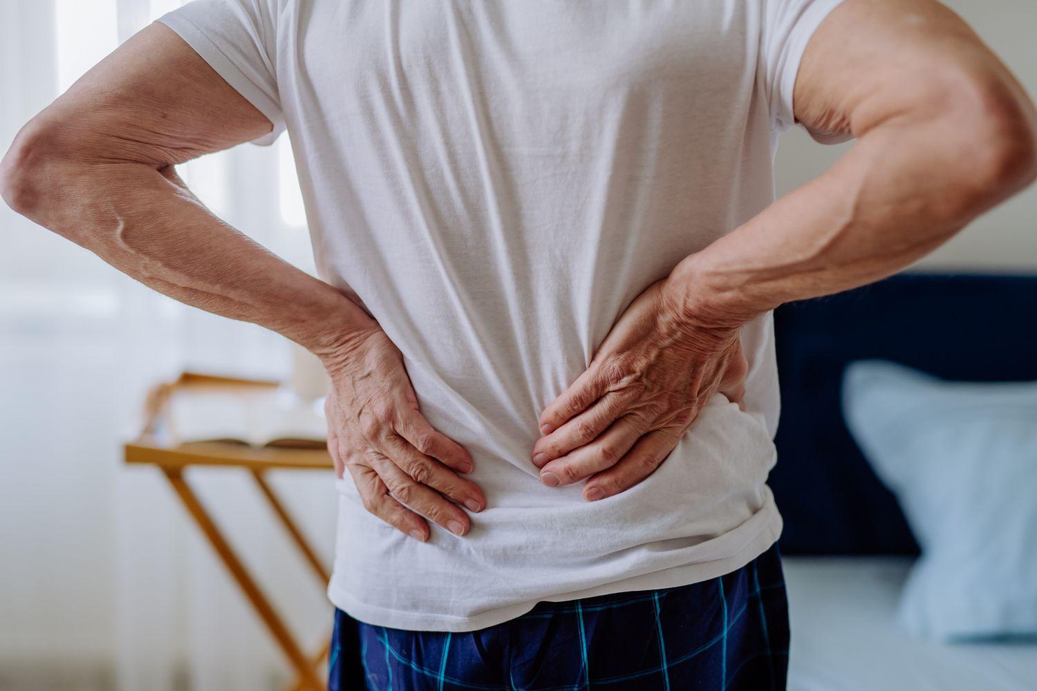 Person holding their lower back in pain — back pain treatment in Fort Wayne