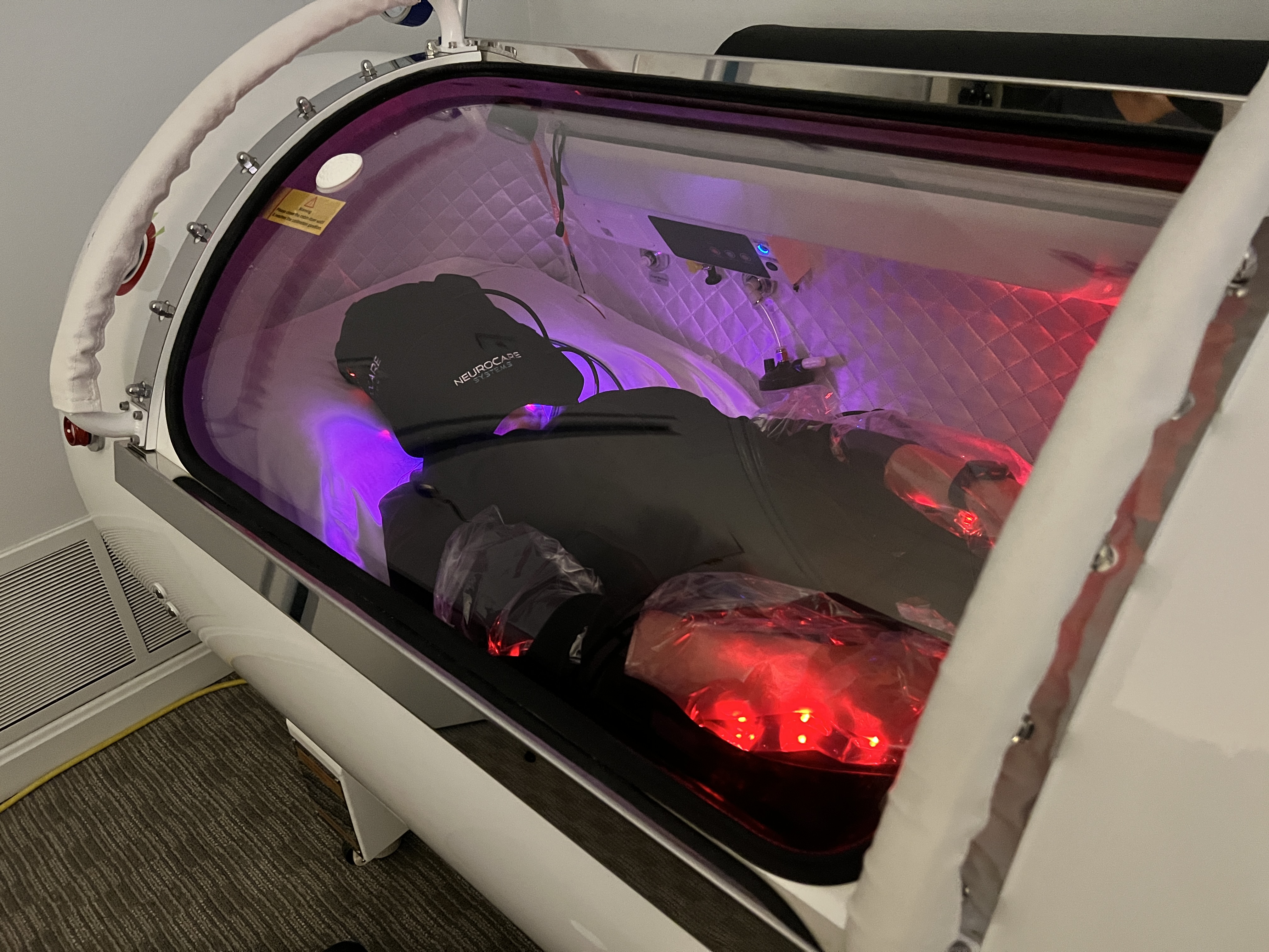 Patient inside the hyperbaric chamber with therapeutic light therapy
